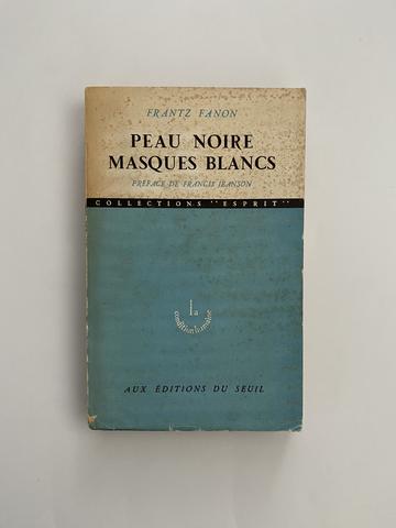 Image depicts the cover of the first edition of Franz Fanon's 'Peau Noire, Masques Blancs'. Blue and white cover, 1950s.