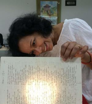 Photo of Nandini Das looking at book. 