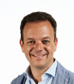 Photo of Filippo de Vivo in front of a white background smiling to camera